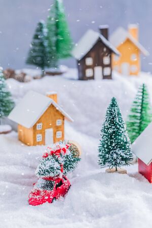 Miniature wooden houses village over blurred Christmas decoration background, property real estate investment greetings conceptの写真素材