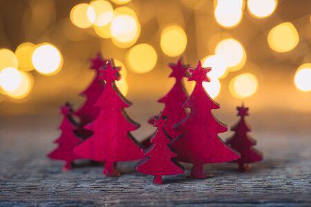 Christmas vintage red wooden firtrees with garland lights background, holiday concept, tonedの写真素材