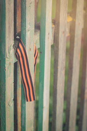 St George's ribbon tied to an old fence, Second World War Victory Day conceptの写真素材