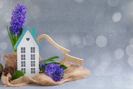 Easter spring daylight postcard composition with fresh blue hyacinth potted and miniature wooden house, happy family holiday conceptの写真素材