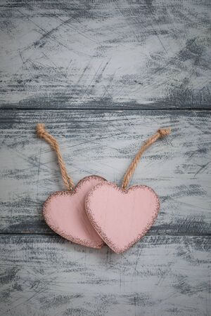 Two pink rustic Valentine's hearts on wooden background, February 14, wedding, proposal, invitation conceptの写真素材