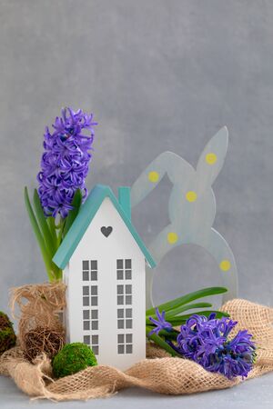 Easter spring daylight postcard composition with fresh blue hyacinth potted and miniature wooden house, happy family holiday conceptの写真素材