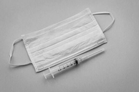 Protective surgical face mask with a syringe, medical doctor care and hygiene conceptの写真素材