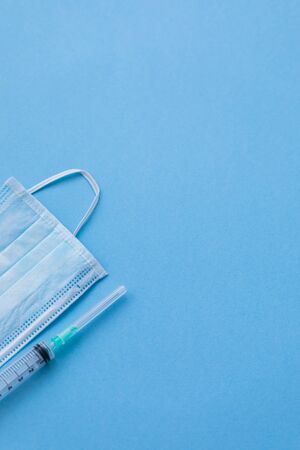 Protective surgical face mask with a syringe, medical doctor care and hygiene conceptの写真素材