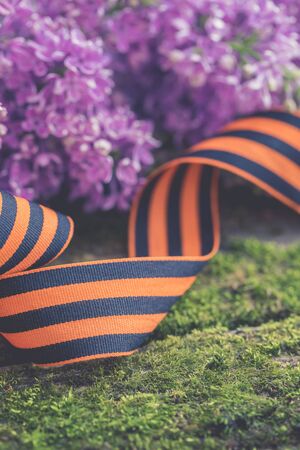 St. George ribbon on natural moss wooden background, symbol of Victory Day May 9, tonedの写真素材