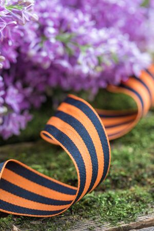 St. George ribbon on natural moss wooden background, symbol of Victory Day May 9, tonedの写真素材