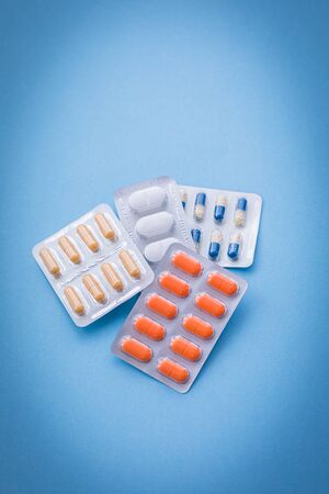 Tablets and pills on blue background, medicine drugs concept, copy spaceの写真素材