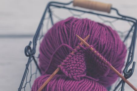 Background with knitting tools and accesories, colorful purple skein yarn, hobby concept, copyspace