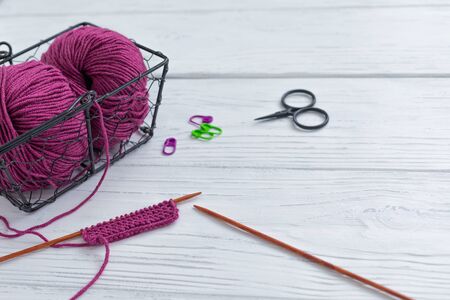 Background with knitting tools and accesories, colorful purple skein yarn, hobby concept, copyspace