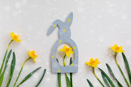 Composition of Easter bunny rabbit frame and yellow daffodil on beige background, flowerscape flat lay, Happy Easter sale or greeting concept postcard with copy spaceの写真素材
