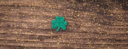 St Patrick day background with shamrock clover leaf on wood, Irish festival symbol, toned, with fairy dust texture, copyspaceの写真素材
