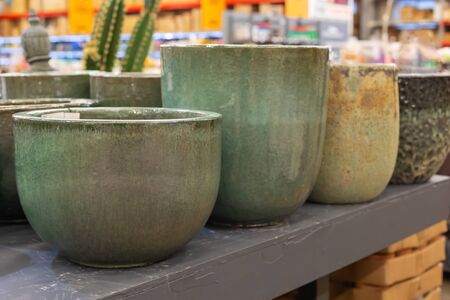 Retro styled green and beige ceramic garden and home plants and flower pots on the shelves