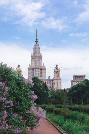 Blossoming pink and purple lilac branche bushes background, copyspace, selective focus, Moscow State University building, 9 May postcard conceptの写真素材