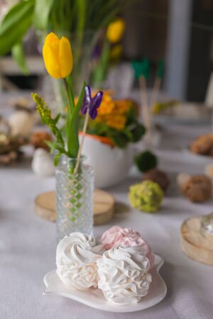 Easter festive spring table setting decoration, marshmallows, tulips, family dinner or breakfast conceptの写真素材