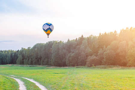 Colorful hot air balloon flying over the countryside in summerの写真素材