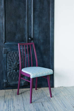 Vintage repainted and renovated wooden chair over the old door, do it yourself conceptの写真素材