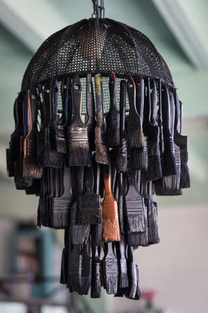 Modern chandelier lamp made of black colored paint brushes, do it yourself conceptの写真素材