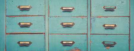 Old turquoise and brown colored wooden file and document cabinet with drawers backgroundの写真素材