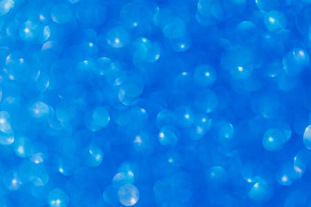 Vivid blue abstract background with bokeh defocused lightsの写真素材
