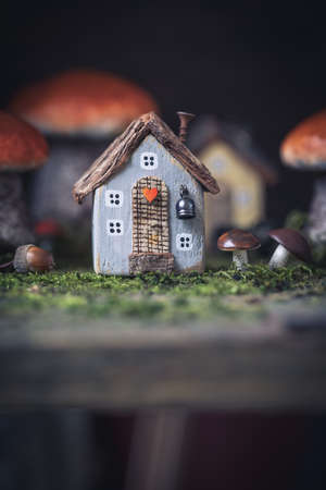 Miniature cozy fairy little autumn cottage, mushrooms, moss backgroundの写真素材