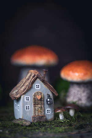 Miniature cozy fairy little autumn cottage, mushrooms, moss backgroundの写真素材