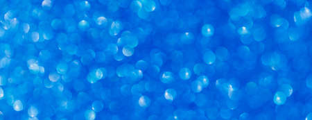 Vivid blue abstract background with bokeh defocused lightsの写真素材