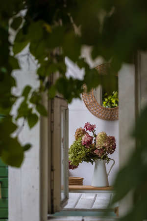 A view from the outside of the dry hydrangea flowers on the wooden background, toned, selective focusの写真素材