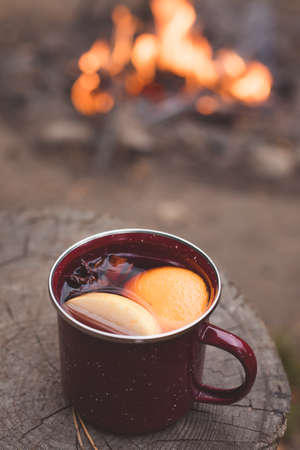 Traditional mulled wine with orange, cinnamon, apples and anise. rustic background, selective focus,...