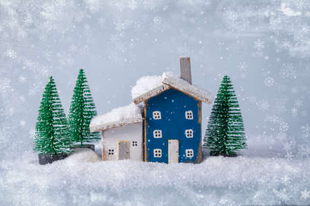 Miniature fairy tale blue and white wooden houses over blurred Christmas decoration background, property real estate investment greetings conceptの写真素材