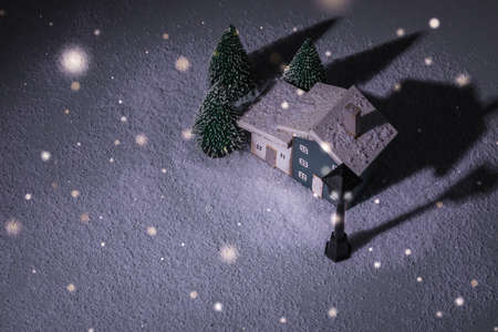 Miniature night fairy tale blue and white wooden houses over blurred Christmas decoration background, property real estate investment greetings conceptの写真素材