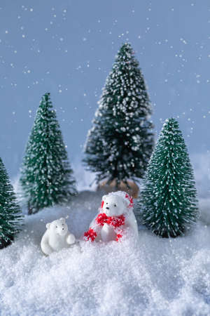 Cute white bears in red knitted scarf on snow in the forest at Christmas night, greeting postcard conceptの写真素材