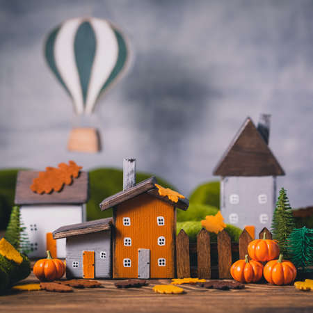 Miniature Thanksgiving Day little fairy autumn cottages, pumpkins, air balloon wooden background, postcard concept, tonedの写真素材