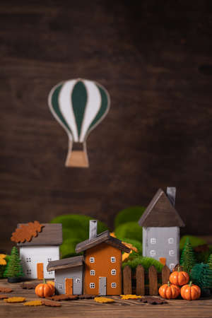 Miniature Thanksgiving Day little fairy autumn cottages, pumpkins, air balloon wooden background, postcard concept, tonedの写真素材