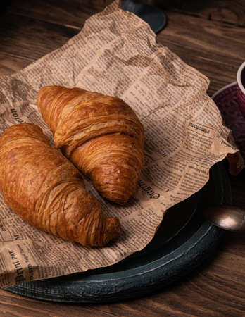 Freshly baked croissants for breakfast on the old paper rustic backgroundの写真素材