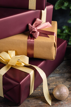Christmas presents witgolden and red ribbons on dark wooden background in vintage styleの写真素材