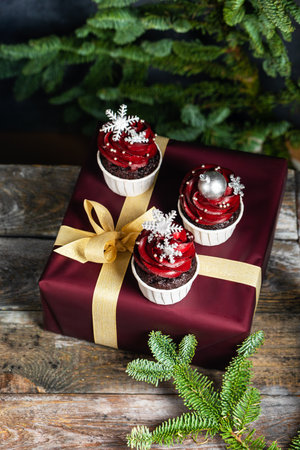 Tasty homemade festive Christmas muffin or cupcake with cream and sweet balls and snowflakesの写真素材