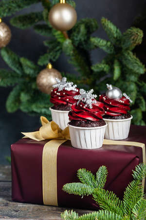 Tasty homemade festive Christmas muffins or cupcakes with cream and sweet balls and snowflakesの写真素材