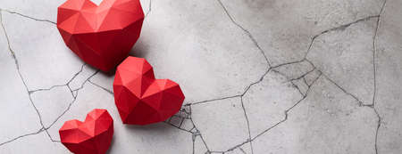 Red paper hearts isolated on grey cracked concrete background, bannerの写真素材