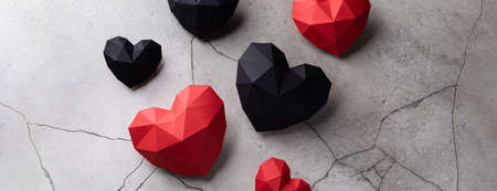 Many red and black romantic paper hearts isolated on grey cracked concrete background, Saint Valentine's Day concept postcard, cardiology health symbol, drama, theater, bannerの写真素材