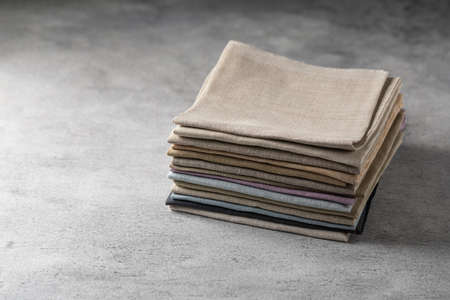 A pile of four folded dull-colored natural linen fabricの写真素材