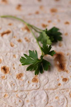 Lavash rolled on a wooden background, thin traditional oriental bread, Armenian flatbread macro, close upの写真素材