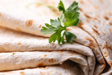 Lavash rolled on a wooden background, thin traditional oriental bread, Armenian flatbread macro, close upの写真素材