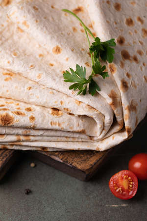 Lavash rolled on a wooden background, thin traditional oriental bread, Armenian flatbread macro, close upの写真素材