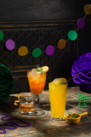 Alcoholic beverage cocktails, purple, green and gold Mardi Gras beads, masks decoration on dark rustic background, festive holiday conceptの写真素材