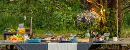 Golden organic healthy crispy pie with artichokes, glasses of wine, fruits on the tableの写真素材