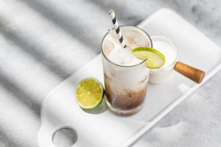 Trendy authentic dirty soda cocktail with cola, lime juice and cream in the kitchen table, top viewの写真素材