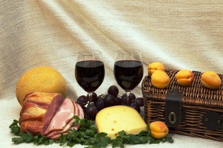 Wine, fruit, ham, cheese and a basketの写真素材