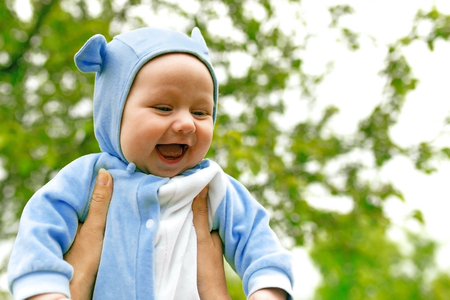 laughing baby on a background of treesの写真素材