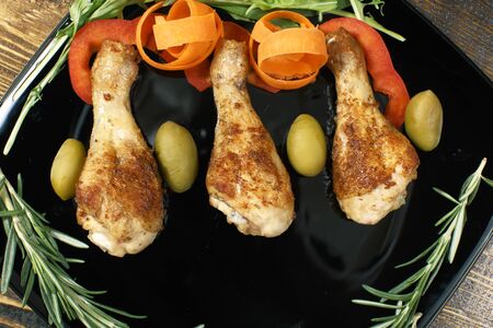 Fried chicken legs with vegetables on a square plate
