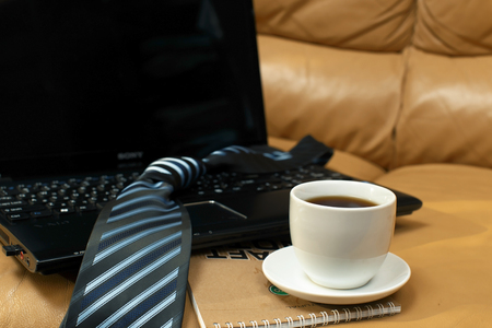 cup of coffee on a notebook on a laptop backgroundの写真素材